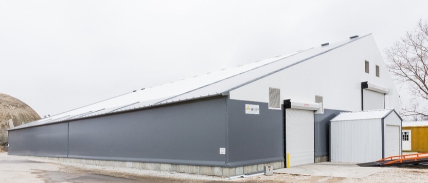 Hybrid building system using metal supports and durable fabric roofing