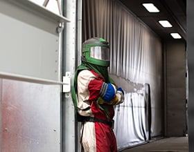 worker inside blasting booth