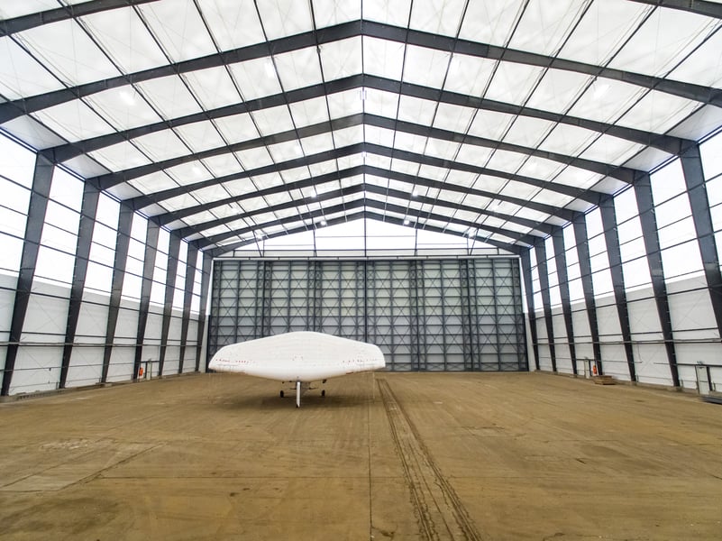 interior of a fabric aircraft assembly hangar with solar-powered aircraft